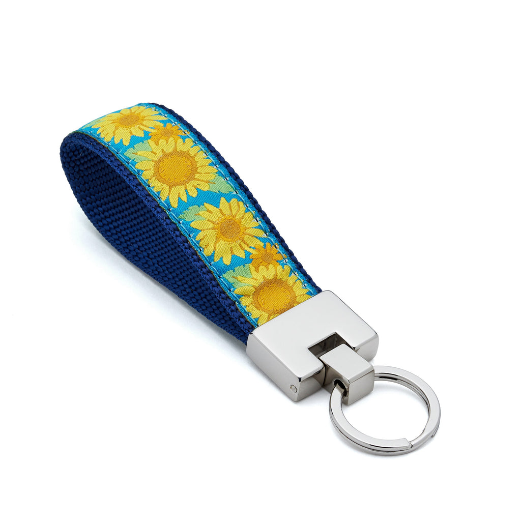 Keychain with sunflower pattern on a blue strap against a white background