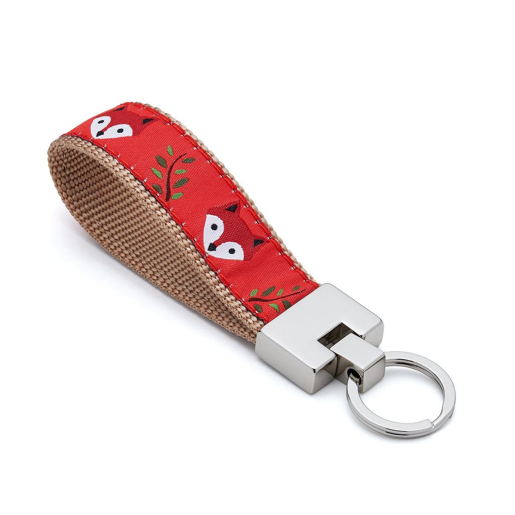 Keychain with red fox pattern on a beige strap on a white background