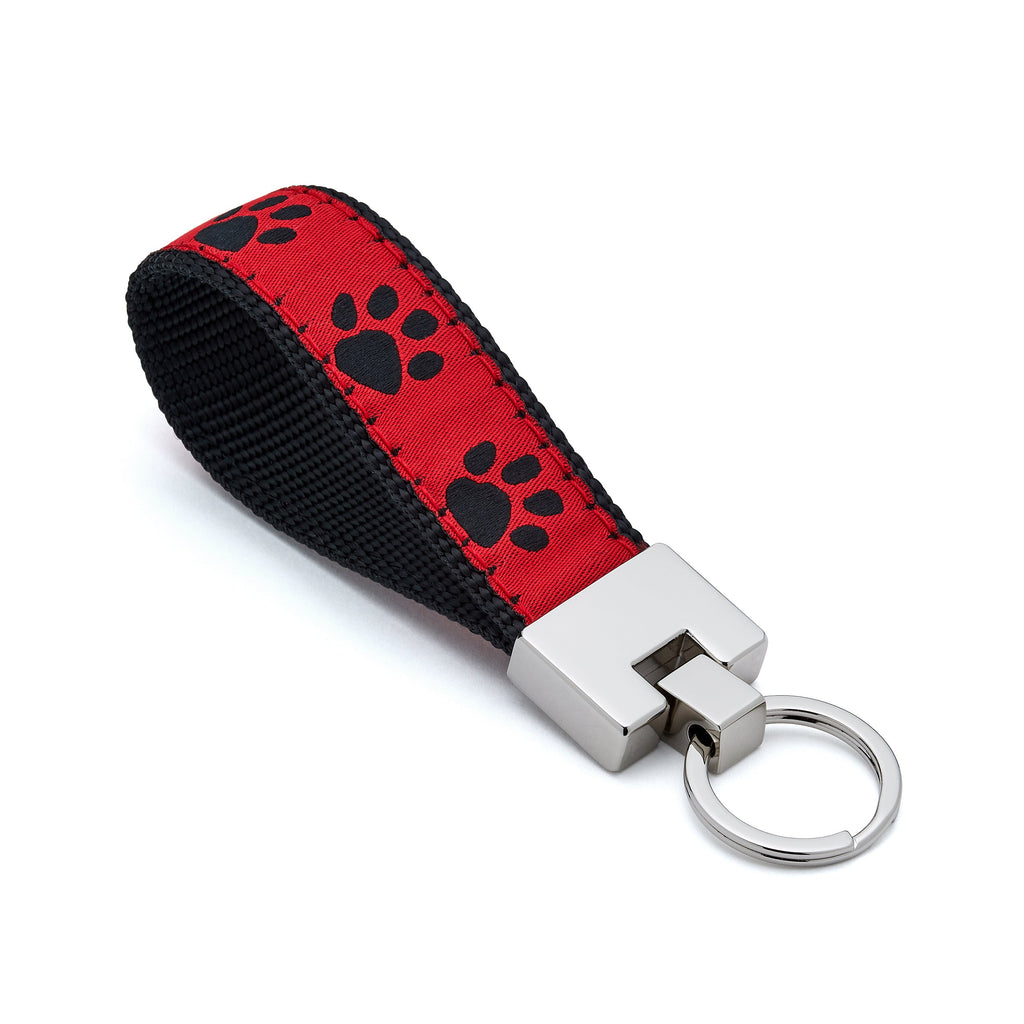 Keychain with red strap featuring black paw prints and silver key ring on a white background