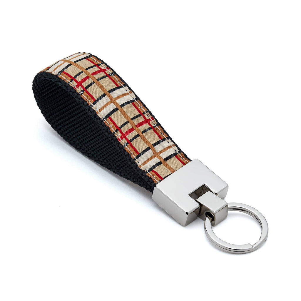 Keychain with plaid patterned strap and metallic keyring on a white background