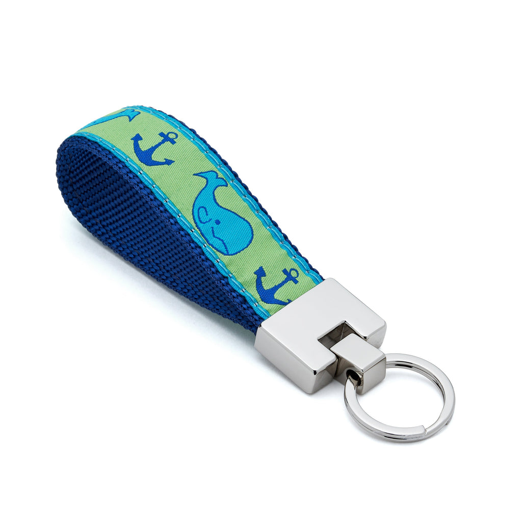 Keychain with blue and green strap featuring whale and anchor designs on a white background